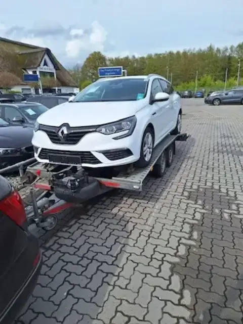 Bílé SUV naložené na přívěsu