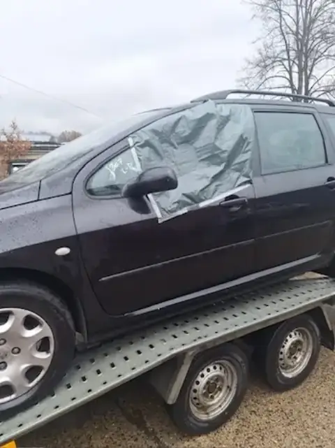 Tmavý vůz při nakládce na přívěs