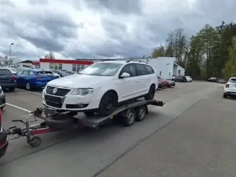 Bílý VW Passat kombi na přívěsu
